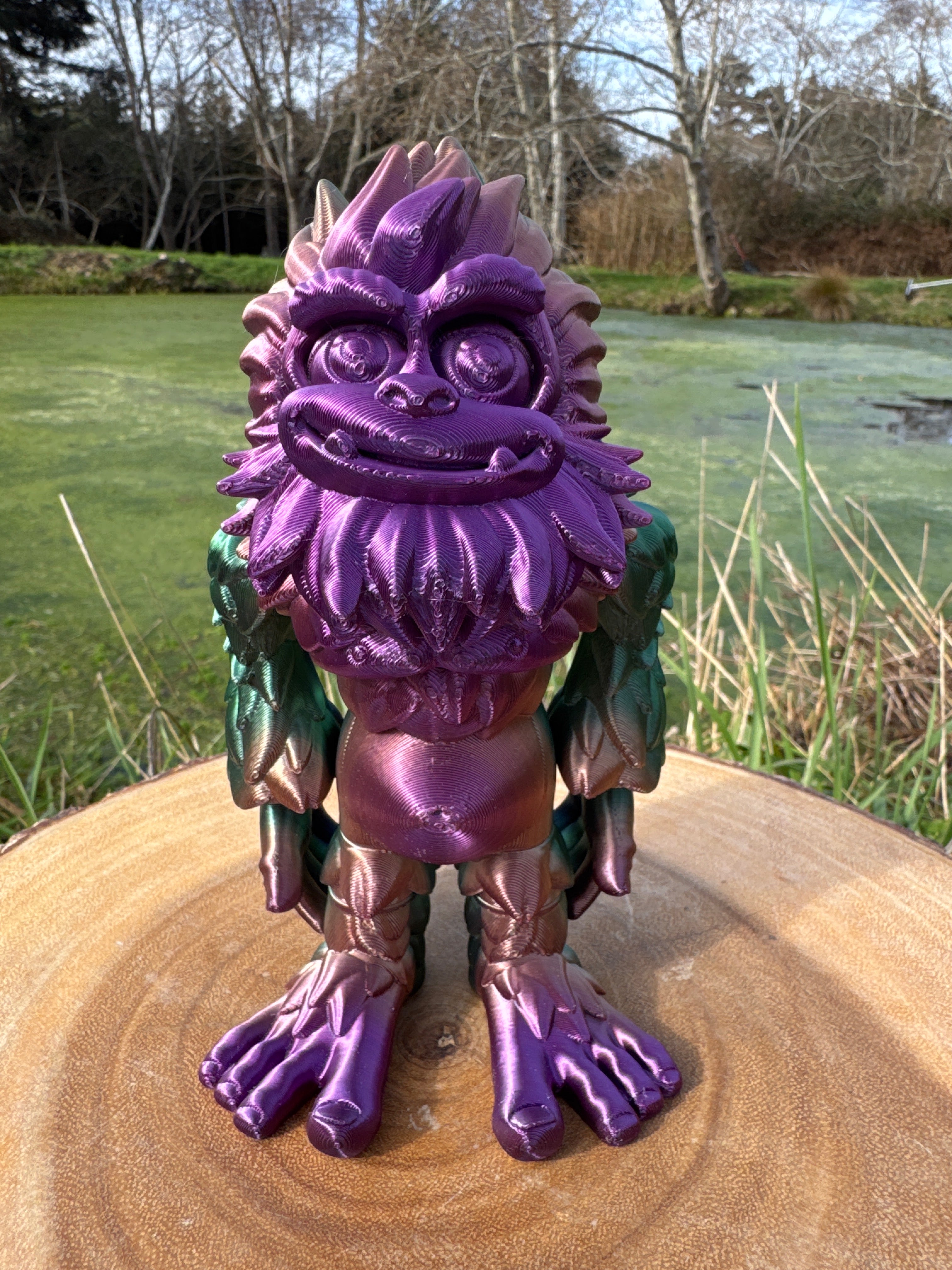 Purple and green dragon-like creature on a wooden log with a natural background